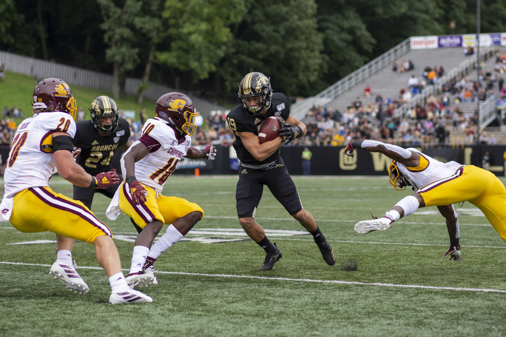 Wide receiver Cam Cooper (19) dodges defensemen during the game against rival Central Michigan University.